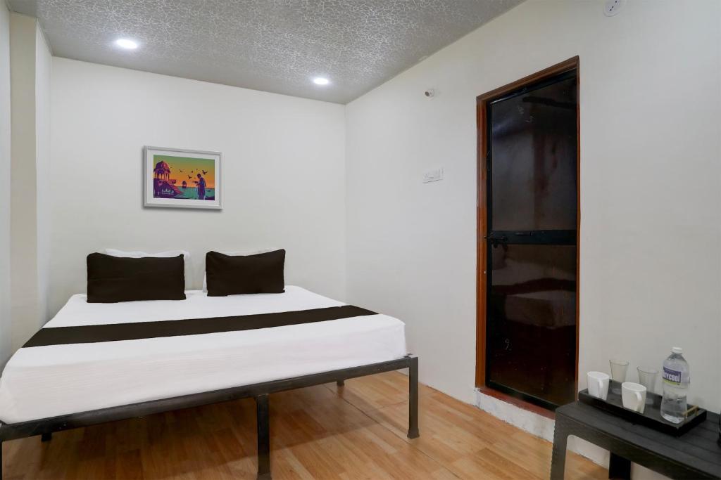 a white room with a bed and a window at Hotel O Sky Villa in Nagpur