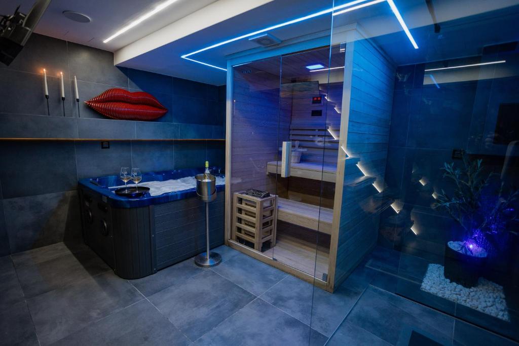 a blue bathroom with a shower and a sink at The Golden Wolf - Wellnes & Spa Luxury Apartment - SELF CHECK IN - FREE PARKING in Vukovar