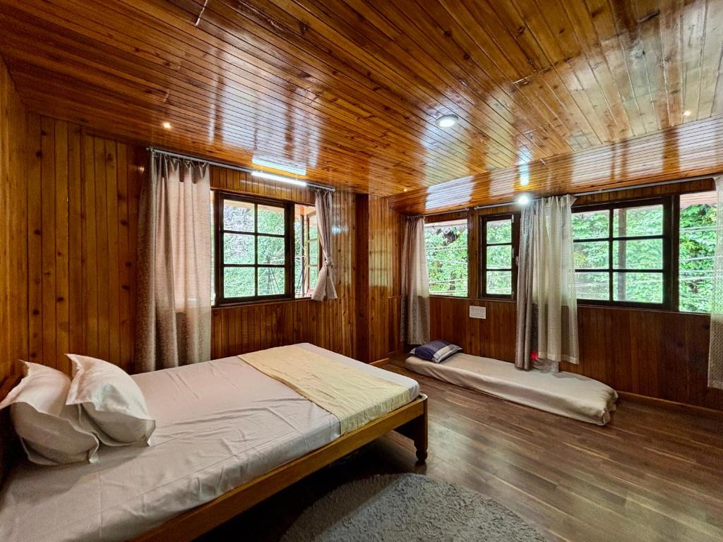 a bedroom with a bed in a wooden cabin at ukiyo homes in Darjeeling