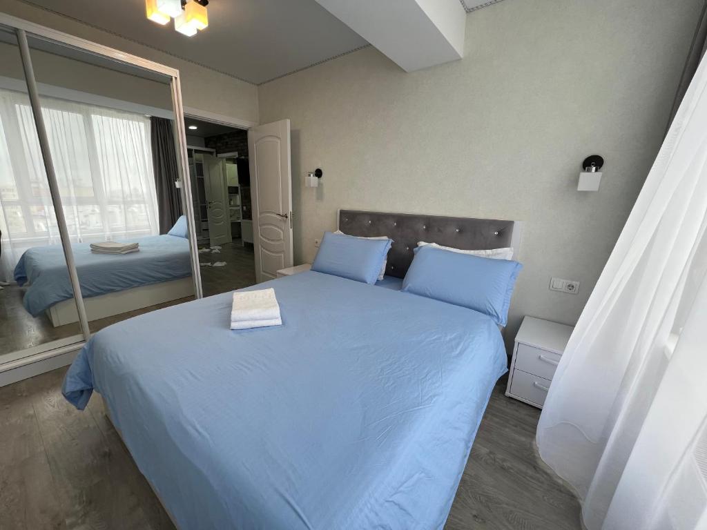 a bedroom with a large blue bed with a mirror at Chișinău MallDova in Chişinău
