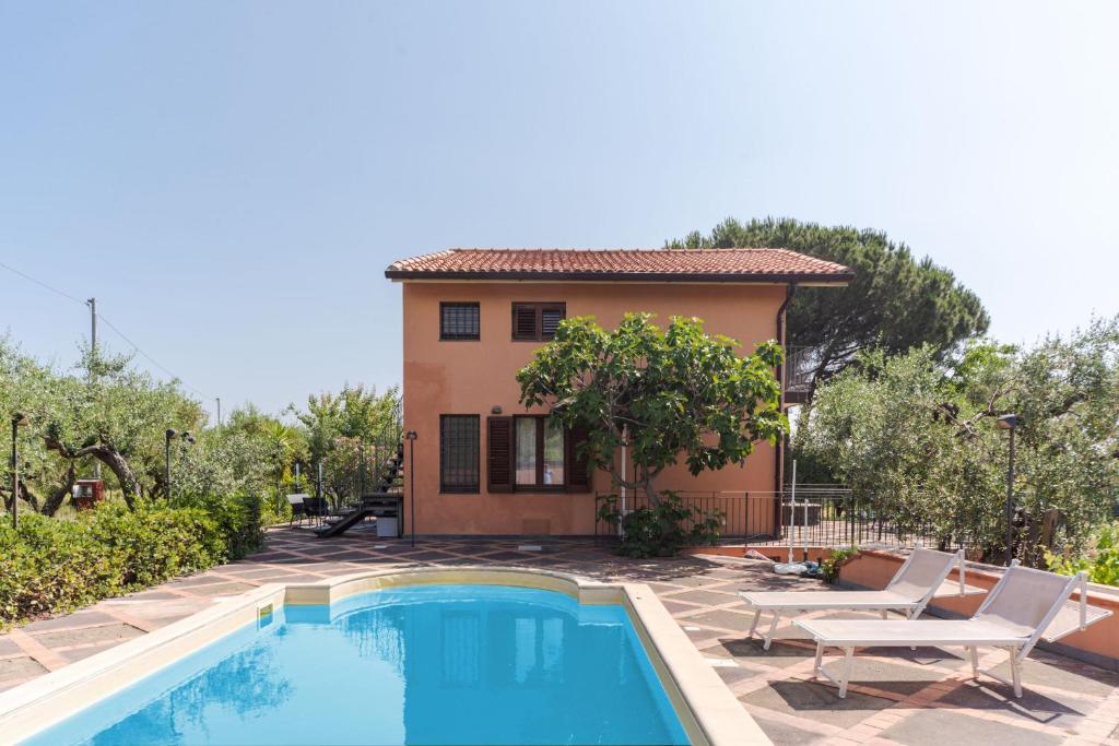 a villa with a swimming pool in front of a house at IL BAGLIO DELL'ETNA VILLA's in Linguaglossa
