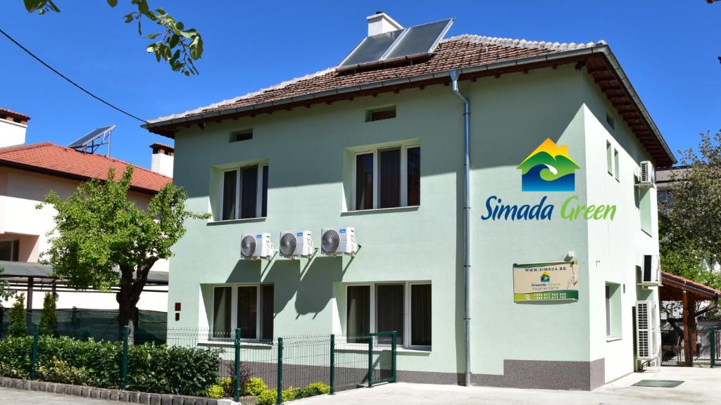 a building with a sign on the side of it at Simada Green Guesthouse in Varshets