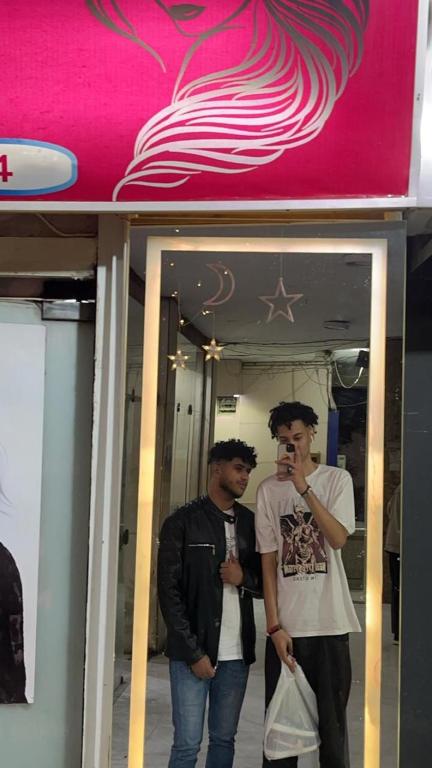 two men standing in front of a store at Crest Pyramids View Inn in Nazlet el-Sîsi
