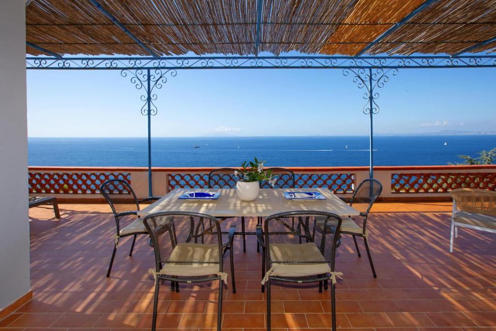 马萨鲁布朗斯Il Respiro del Mare con vista Capri的海景甲板上的桌椅