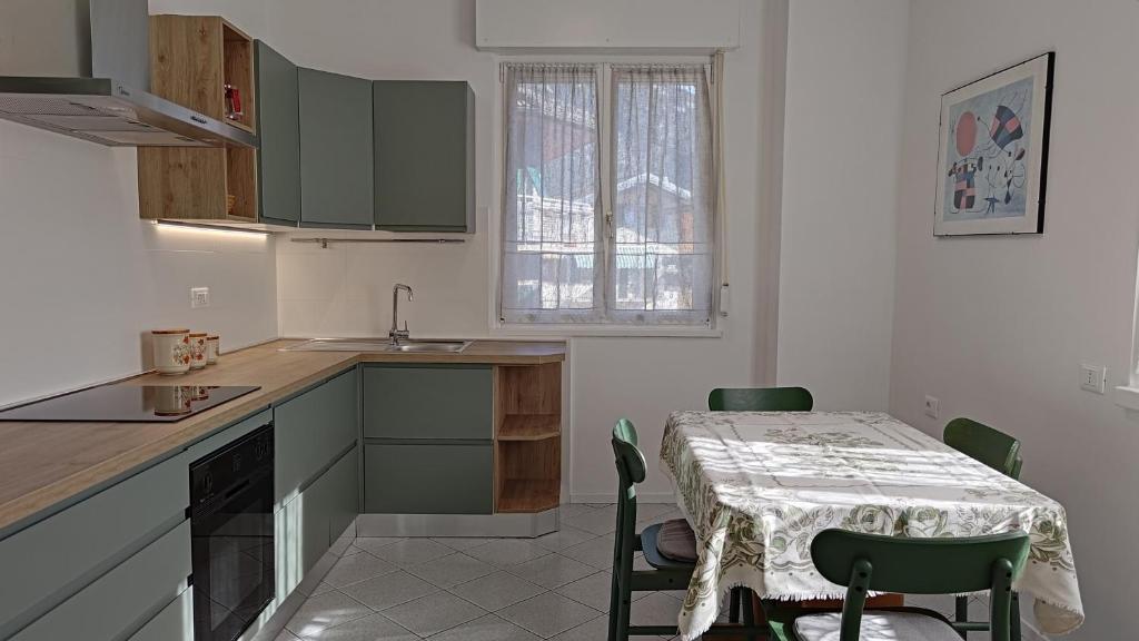 eine Küche mit einem Tisch und einem Tisch und Stühlen in der Unterkunft Casa Rio Maggiore in Levico Terme