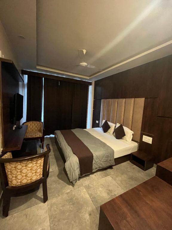 a hotel room with a bed and a chair at Hotel Krishna in Rishīkesh