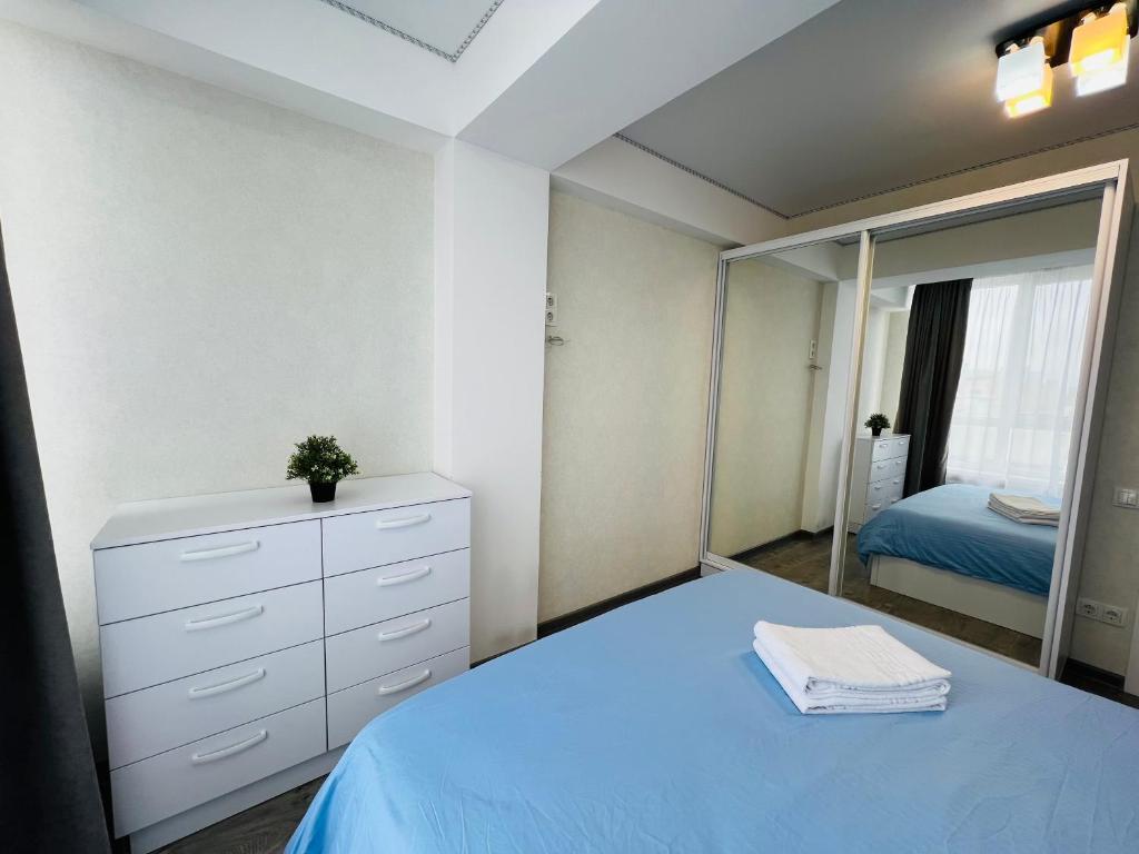 a bedroom with a blue bed and a mirror at Malldova Chișinău centru in Chişinău