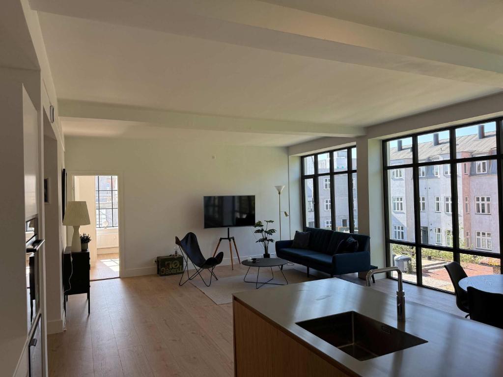 a living room with a couch and a table at Cozy Odense Apartment Long Term Stay in Odense