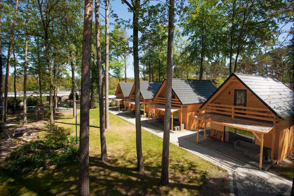 a group of log homes in the woods at Hotel Zielony & OW Borowik & Pensjonat Manhattan - Centrum Rekreacji i Wypoczynku GASTROTUR in Turawa