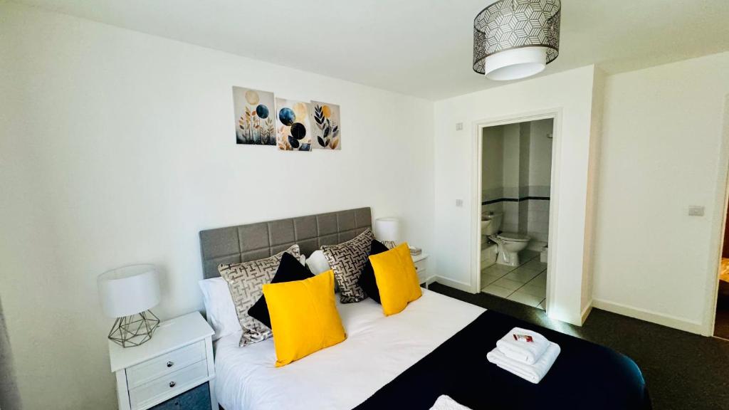 a bedroom with a bed with yellow and black pillows at Spacious Ground Floor 2-Bed Flat - Patio, Parking - By Habitats in Southampton