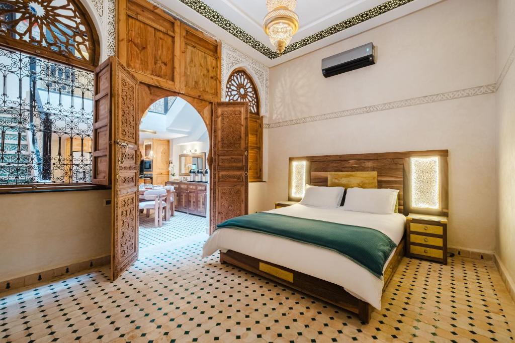 a bedroom with a large bed and a dining room at Riad Emeraude Cozy Riad with Shared Pool 4 Room in Marrakech