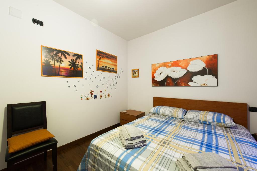 sypialnia z łóżkiem i zdjęciami na ścianie w obiekcie Domus al Parco Guest House w mieście Fiumicino