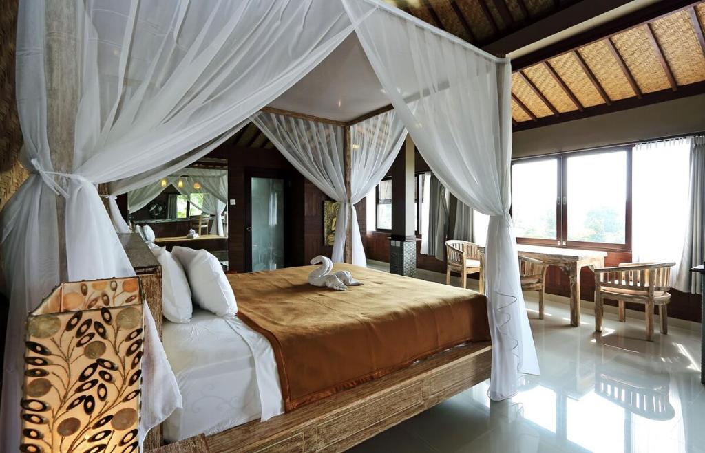 a bedroom with a bed with a canopy at Huge Amazing Campuhan Ridge Walk view room in Ubud