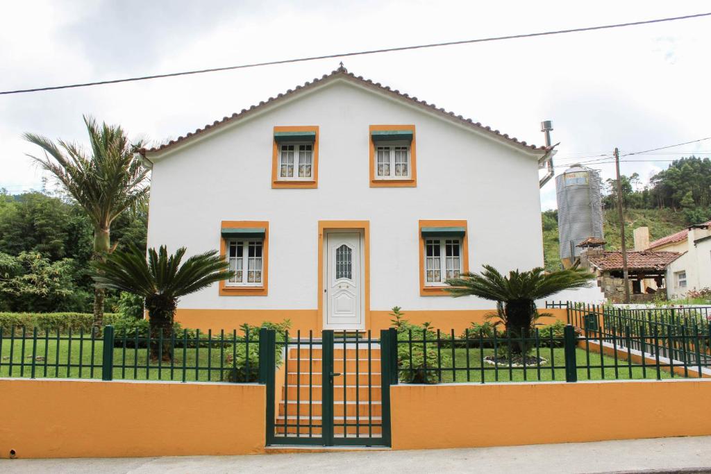 una casa blanca con una valla y palmeras en Echoes of Nature, en Sete Cidades