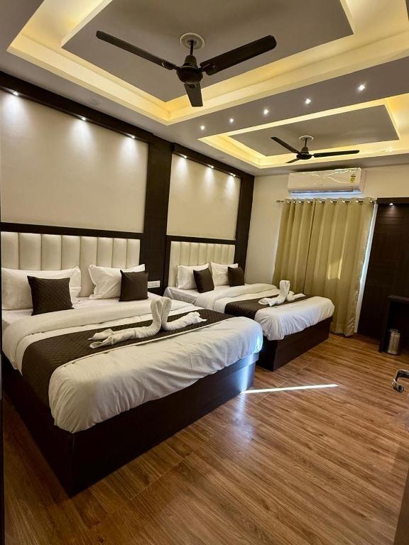 a hotel room with two beds and a ceiling at Hotel KABIR ROYAL-5 MIN WALK TO GOLDEN TEMPLE in Amritsar