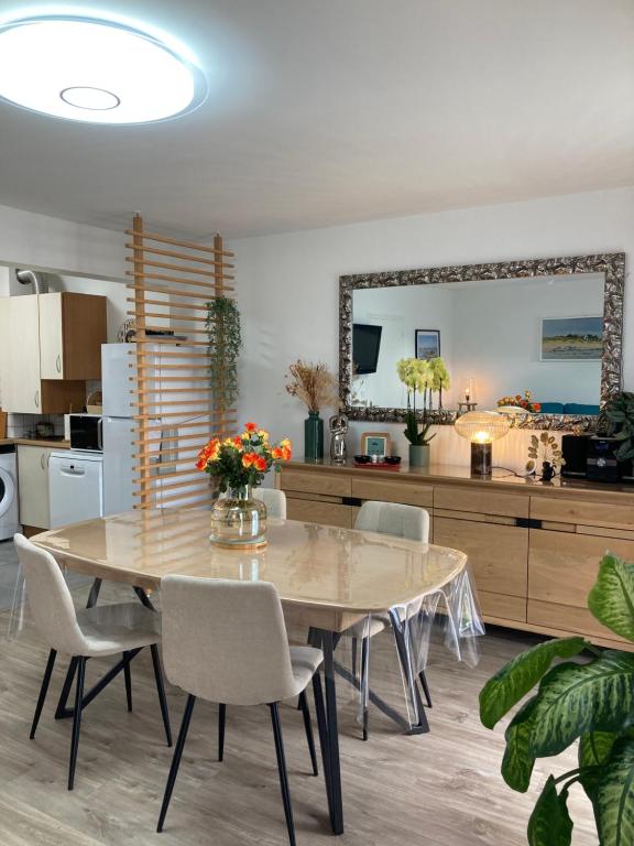 a dining room with a table and chairs and a kitchen at Résidence le 46 in Concarneau