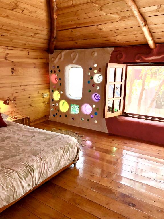 a bedroom with a bed and a wall with a window at Casa Inspirada in Los Estancos