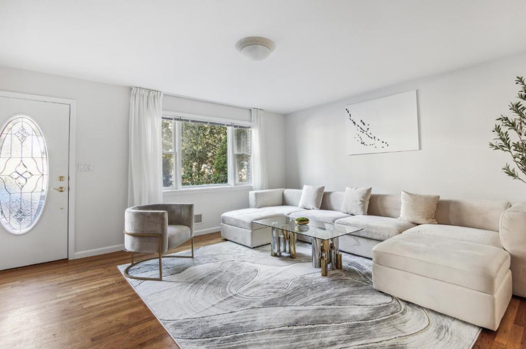 a white living room with a couch and a table at Luxury NY Home with Game Room and Free Parking in White Plains