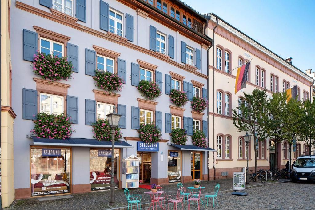 a building with tables and chairs in front of it at Haus Stiegeler - Gottfried Beck in Freiburg im Breisgau