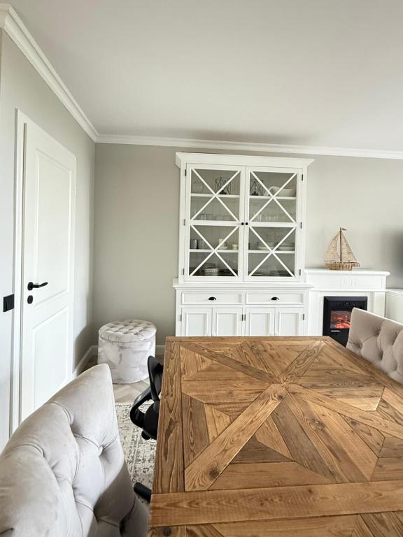 a living room with a wooden table and a white cabinet at Hamptons Beach House Grömitz in Grömitz