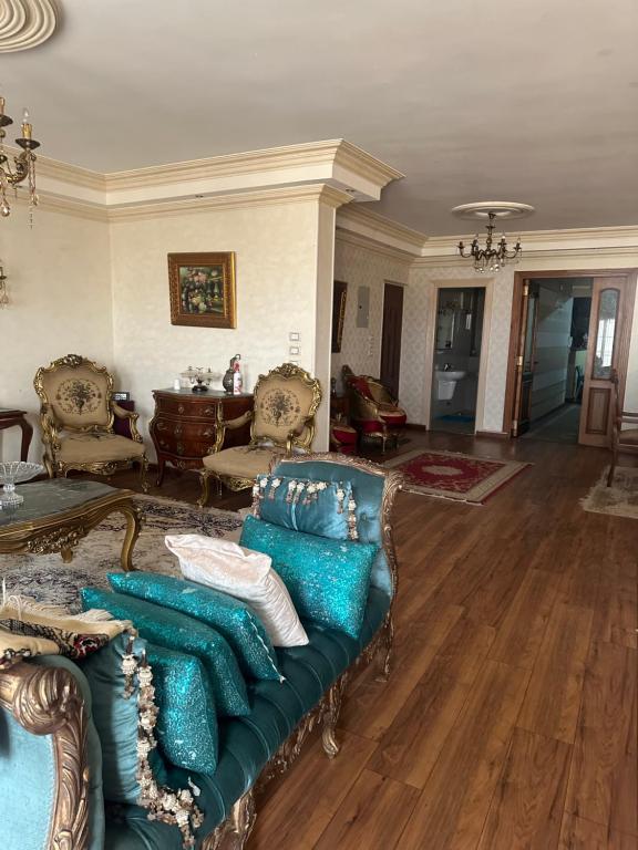 a living room with a couch with blue pillows at Atlantis Palace Pyramids View in ‘Ezbet `Abd el-Ḥamîd