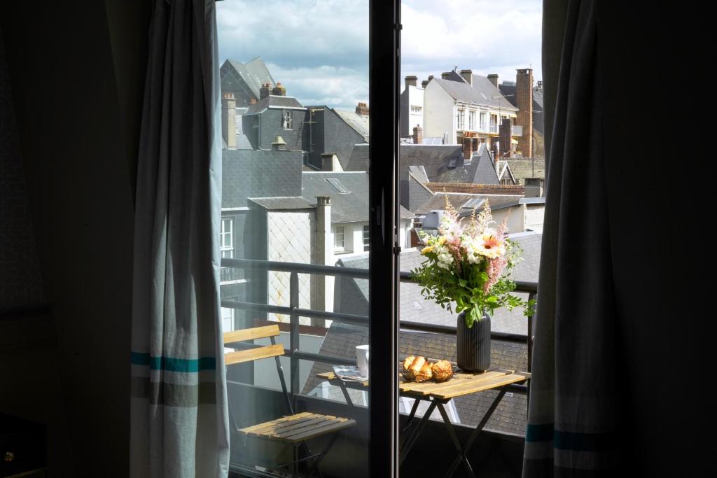 una vista di un balcone con un vaso di fiori su un tavolo di Hôtel Littéraire Gustave Flaubert, BW Signature Collection a Rouen
