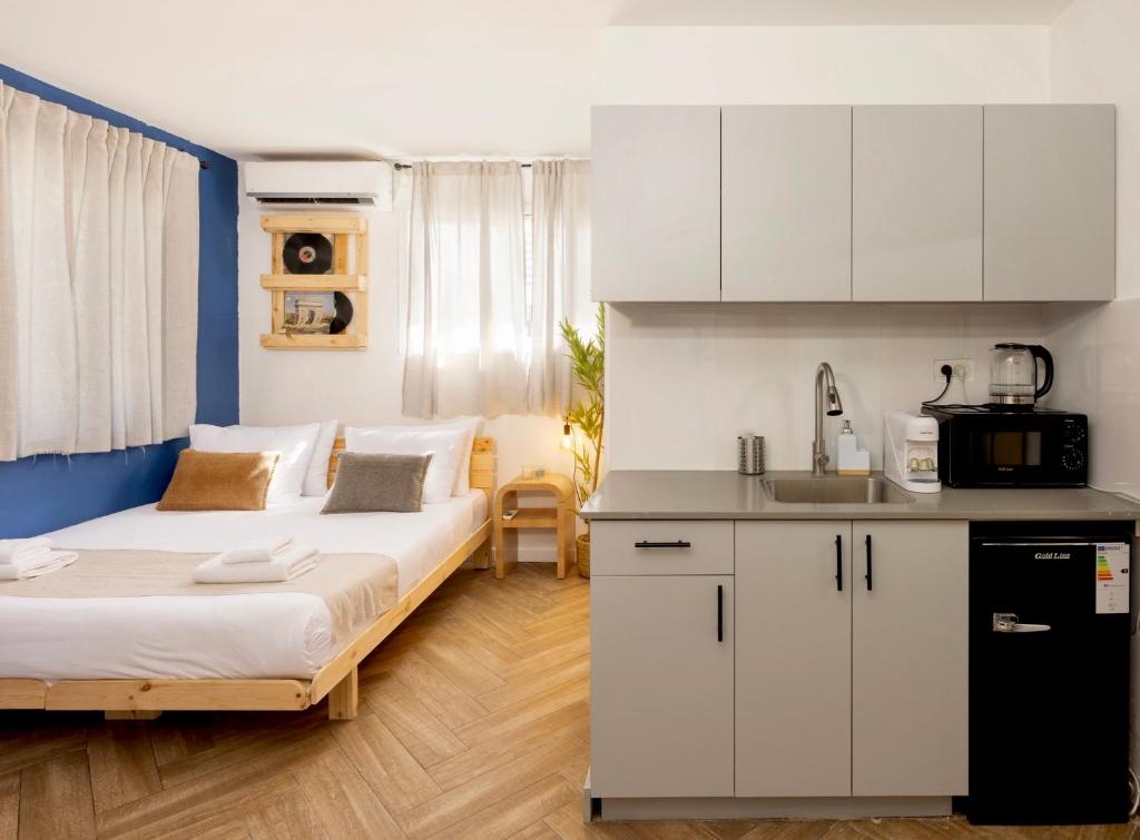 een kleine kamer met 2 bedden en een keuken bij Localz house in Tel Aviv