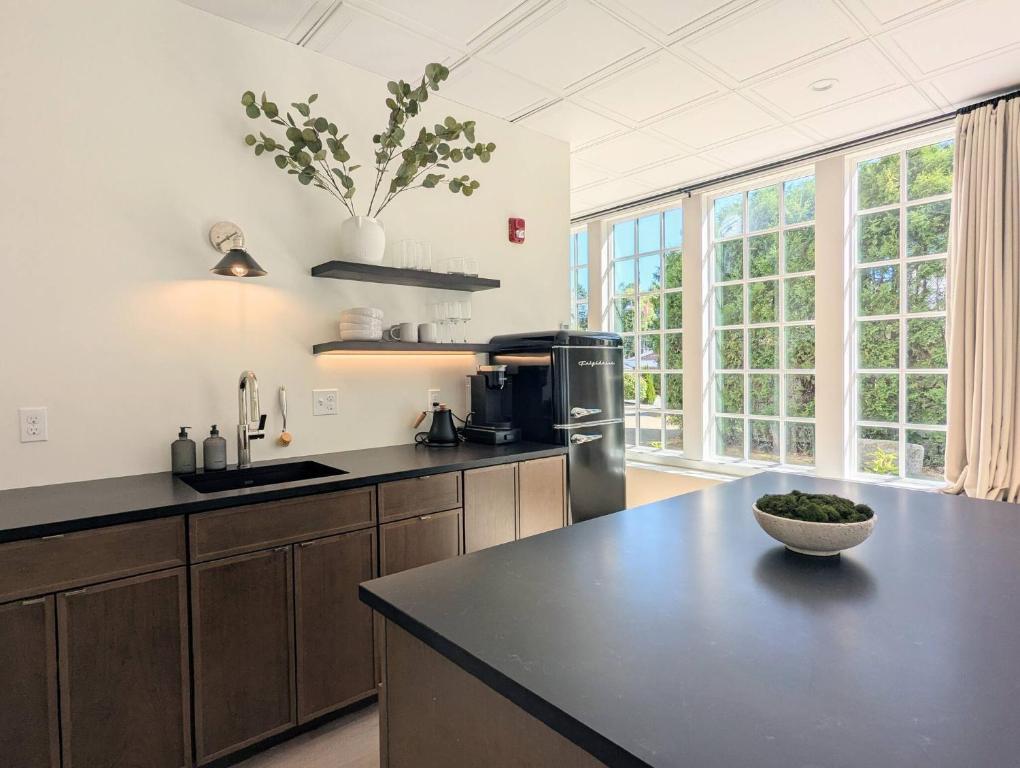 Una cocina con encimera negra y algunas ventanas. en The Optimist Guesthouse | 1, en Camden