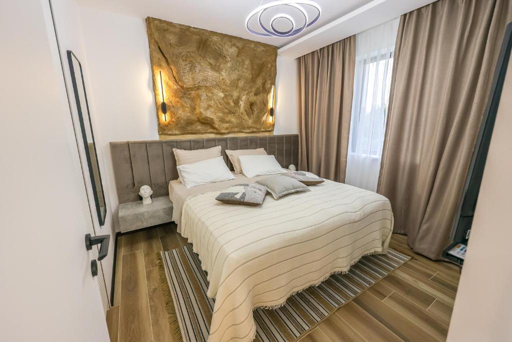 a bedroom with a large bed with a painting on the wall at Apartment Cocosinella in Surčin