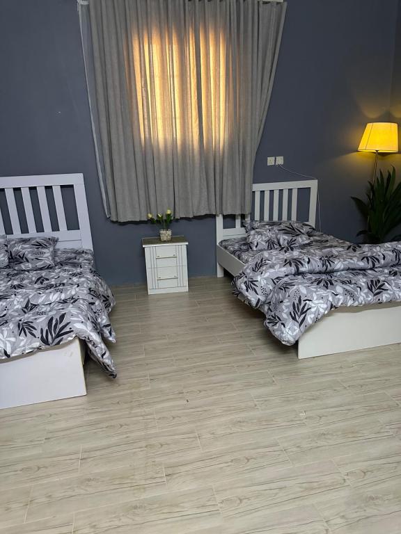 two beds in a room with blue walls at جمعتنا in Al Qā‘id