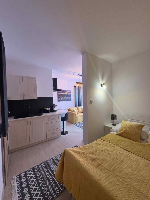 a bedroom with a bed and a living room at Górska Kryjówka 2 in Szlachtowa