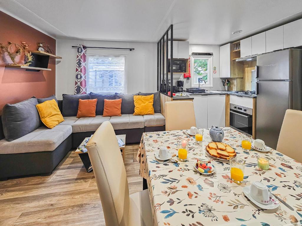 a kitchen and living room with a table and a couch at Forêt & Élégance in Litteau