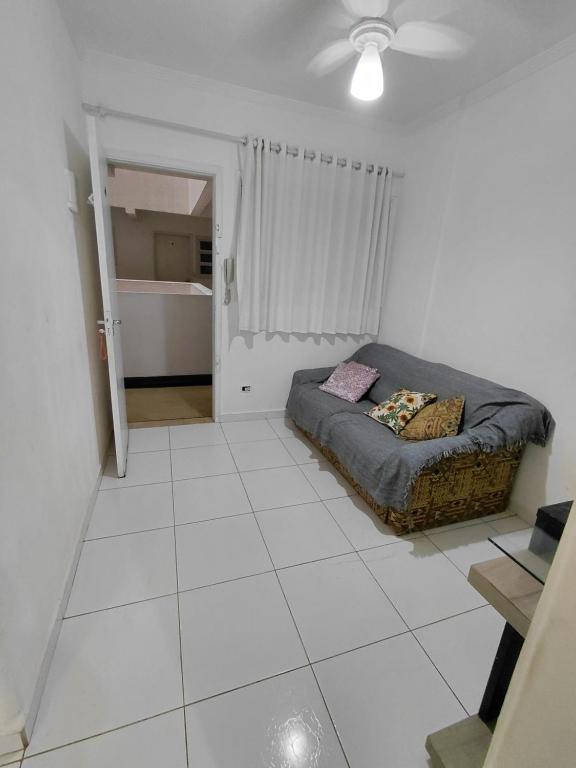 sala de estar con sofá y cama. en Apartamento Mirim, en Praia Grande