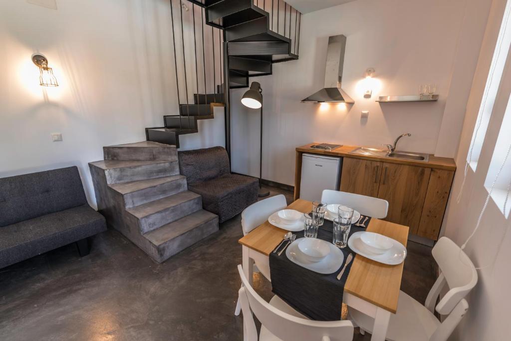 uma sala de jantar com uma mesa e cadeiras e uma escadaria em Anthelia em Skala Potamias