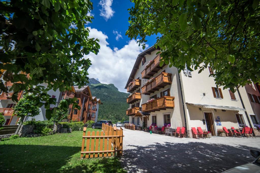 a street in a village with chairs and buildings at Hotel Pavone in Andalo