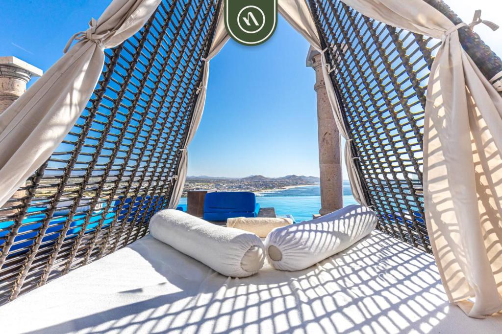 a hammock on a deck with the ocean in the background at Amazing Villa with 3BR - Private Pool in El Tule