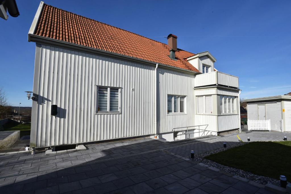 biały budynek z czerwonym dachem w obiekcie Very nice basement apartment in Molndal outside of Gothenburg w mieście Mölndal