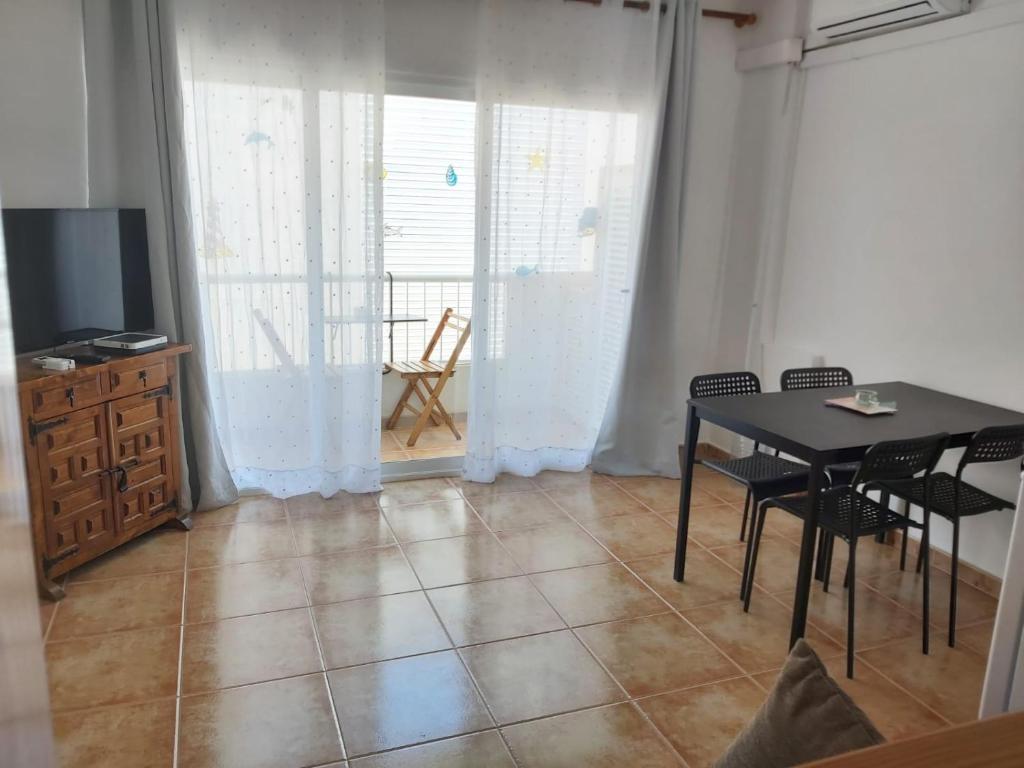 une salle à manger avec une table, des chaises et une télévision dans l'établissement Apartamento Vista ET88PL, à Es Pujols