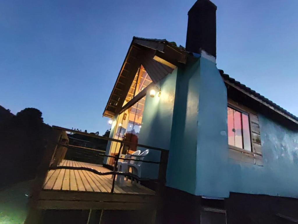 a house with a wooden deck with a building at Cabana Rustica com Hydro, Recanto das Trutas, SC in Bocaina do Sul