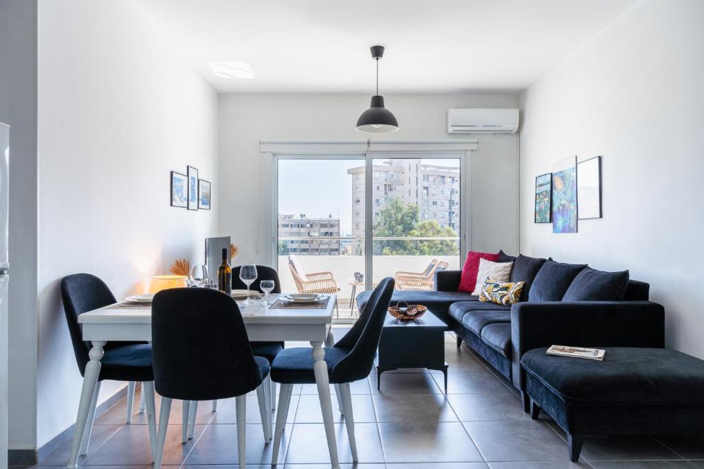 a living room with a couch and a table and chairs at Phoenix 2-Bedroom Apartment in Larnaca