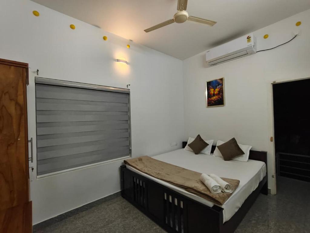 a bedroom with a bed and a ceiling fan at Rohini Homestay & Serviced Villa-Explore Alleppy in Alleppey