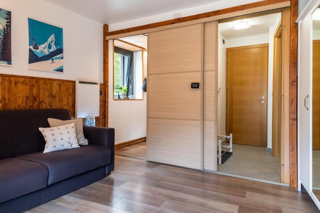 a living room with a couch and a sliding glass door at MCX Vacation Rental - Belle Vue Les Grandes Murailles, Pet Friendly Apartment just 300 meters from the ski lifts! in Breuil-Cervinia