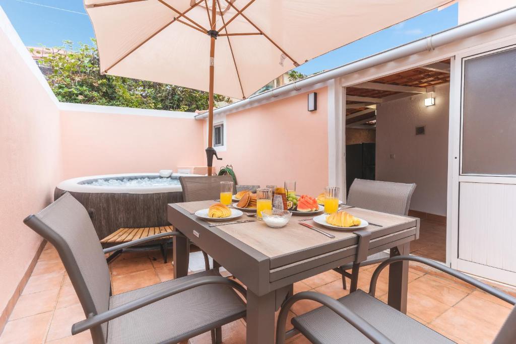 a table with chairs and an umbrella on a patio at Stero House by Atlantic Holiday in Caniçal