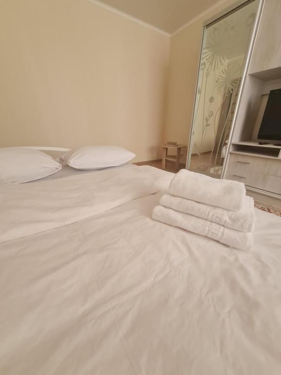 Una cama blanca con dos toallas encima. en Апартаменти в центрі, en Lutsk