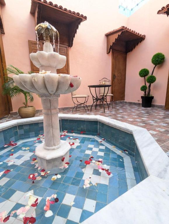 a fountain in the middle of a swimming pool at Dar BERNANI in Rabat