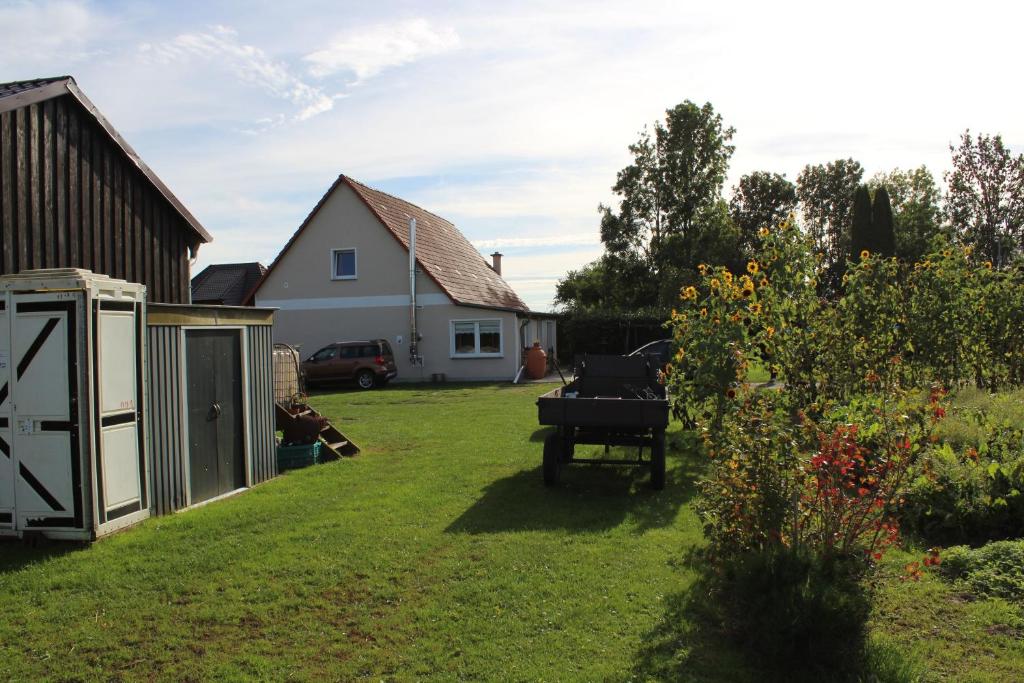 a backyard with a grill and a house at Ferienwohnung "Feldblick" Schuhmacher in Gützkow