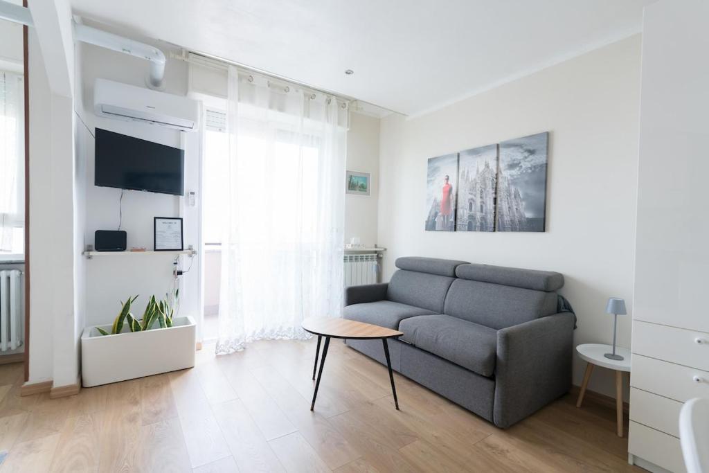 a living room with a couch and a table at Eleventh Floor apartment Milano in Cinisello Balsamo