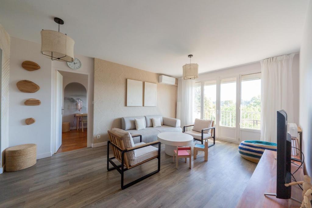 un soggiorno con un divano e un tavolo di Art de Recevoir - Prestige & Vue Panoramique sur Saône - Parking Privé T3 Appartement Climatisé a Fontaines-sur-Saône