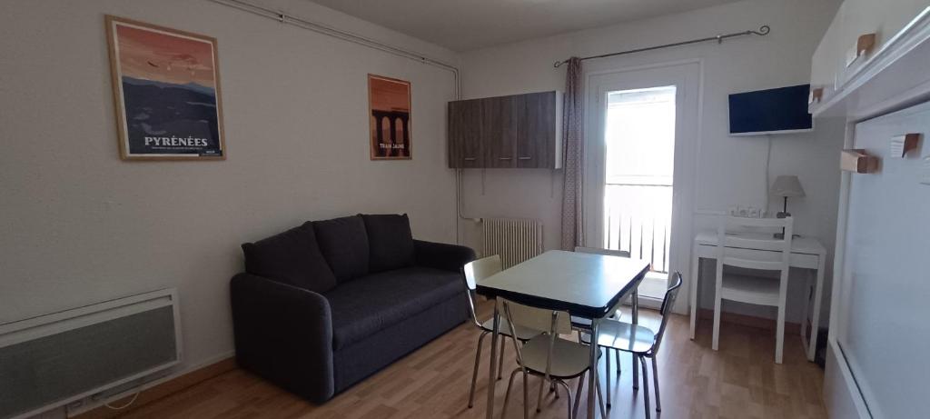 a living room with a couch and a table at Studio agréable tout confort in Les Angles