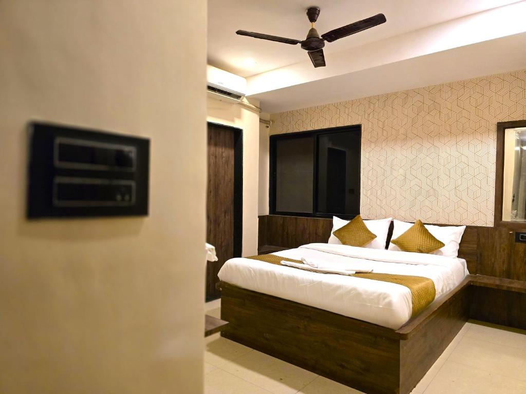 Un dormitorio con una cama y un ventilador de techo. en Hotel City Airr - BUDGET HOTEL, en Pune